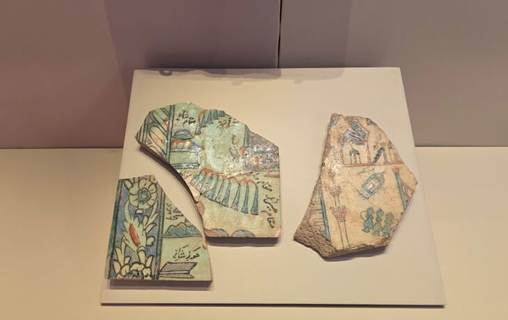 İznik Müzesi’nde sergilenen Türk-İslam dönemine ait İznik çinilerinin bitkisel motifler, kaligrafik süslemeler ve pastel renklerle bezeli parçalarının detaylı görünümü.